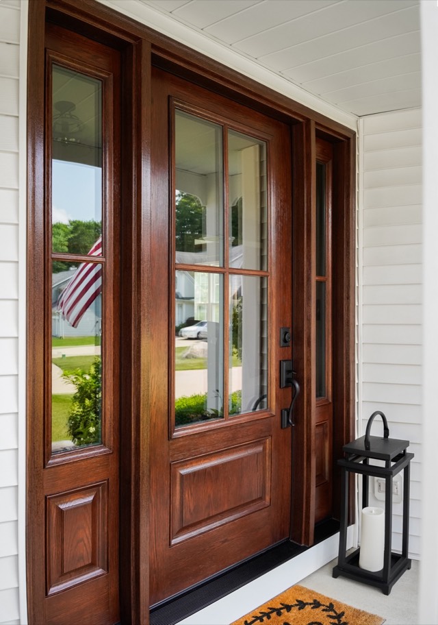Woodgrain entry door with sidelites on a front porch