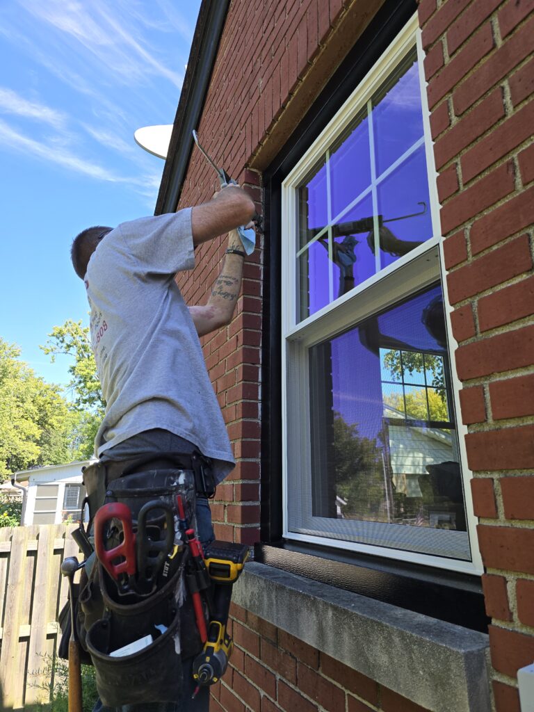 Professional installer fitting an energy-efficient double-hung window in an Indianapolis home, ideal for window replacement to improve ventilation, ease of cleaning, and energy conservation. This image highlights the popular choice among homeowners in Carmel and Greenwood looking to upgrade their home's thermal performance and curb appeal with durable, high-quality windows.